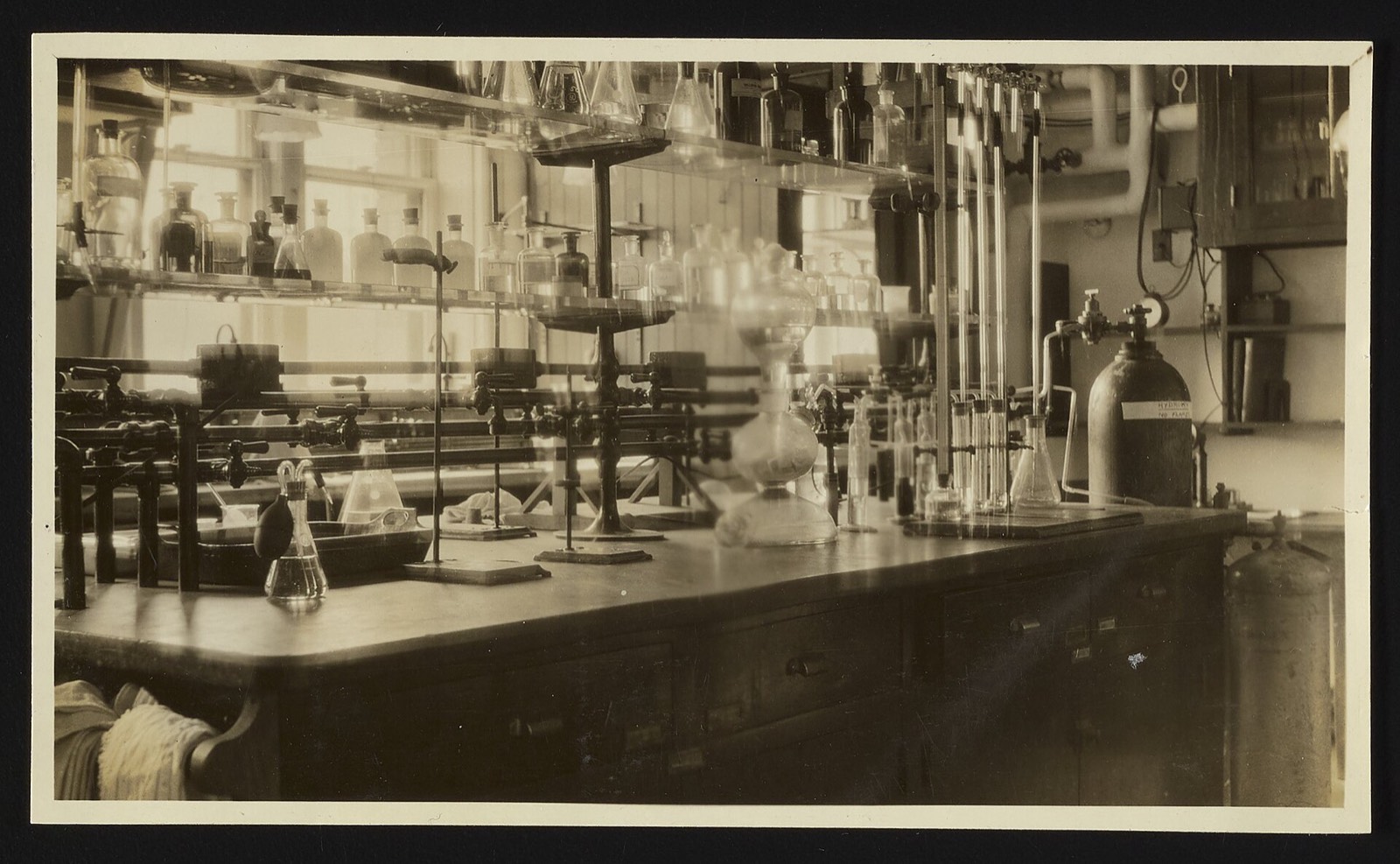 A laboratory bench with shelves of glassware and a row of balances at the Hospital of the Rockefeller Institute